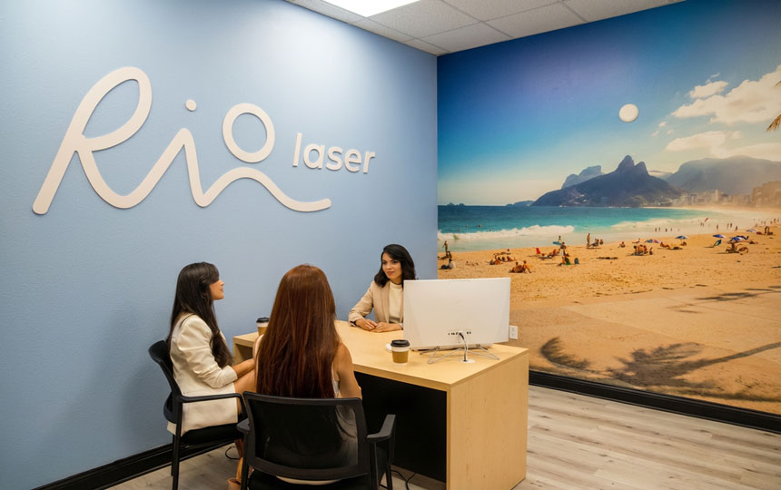 Client being assisted at Riolaser Orlando reception, with the receptionist explaining the laser hair removal procedure using a tablet, showcasing the process in a professional clinic setting.