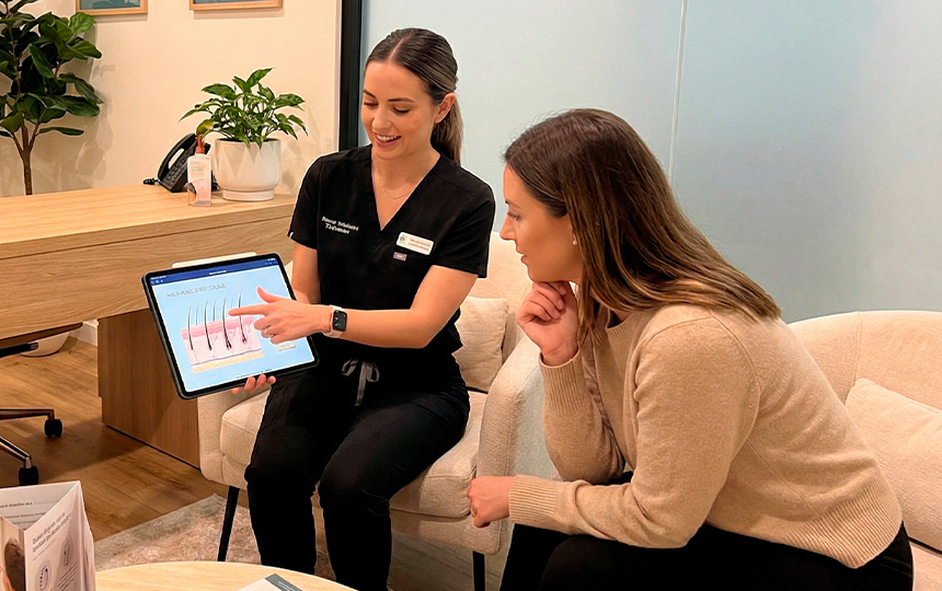 Client being assisted at Riolaser Orlando reception, with the receptionist explaining the laser hair removal procedure using a tablet, showcasing the process in a professional clinic setting.