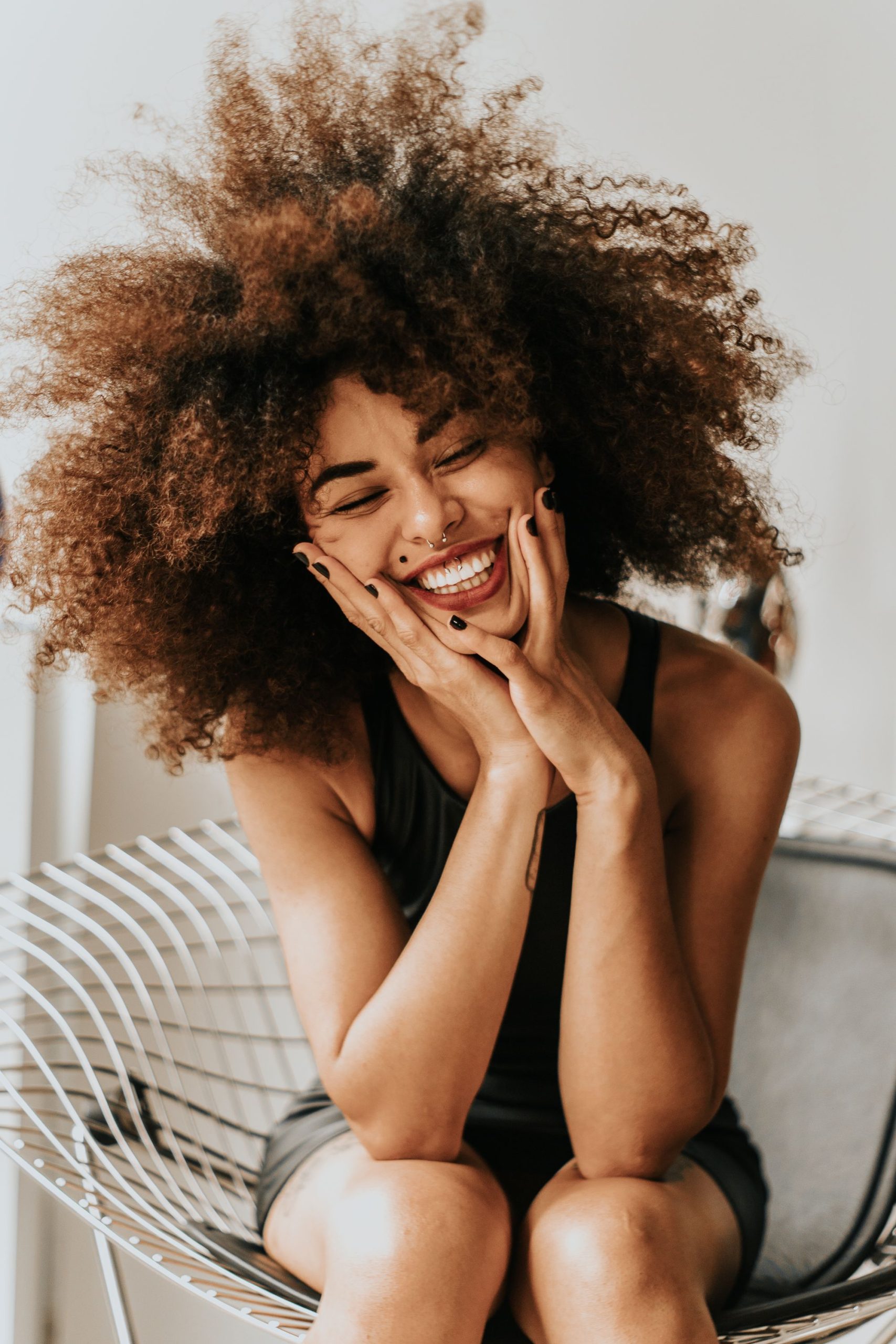 Woman with darker skin smiling confidently after professional laser hair removal results